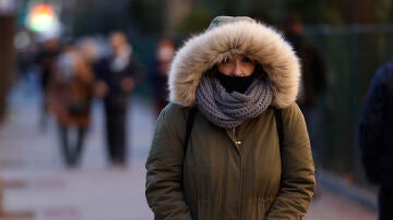 Una mujer pasea por Madrid en una fría mañana.