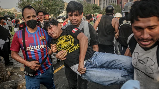 Varias personas socorren a un hombre afectado tras los enfrentamientos entre manifestantes y la Policía en Perú Varias personas socorren a un hombre afectado tras los enfrentamientos entre manifestantes y la Policía en Perú