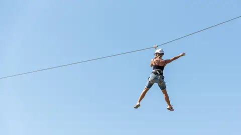 Joven tirándose por una tirolina Joven tirándose por una tirolina