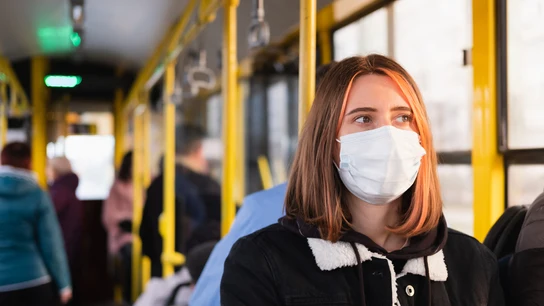 Una chica en un autobús con mascarilla Una chica en un autobús con mascarilla