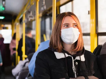 Una chica en un autobús con mascarilla Una chica en un autobús con mascarilla