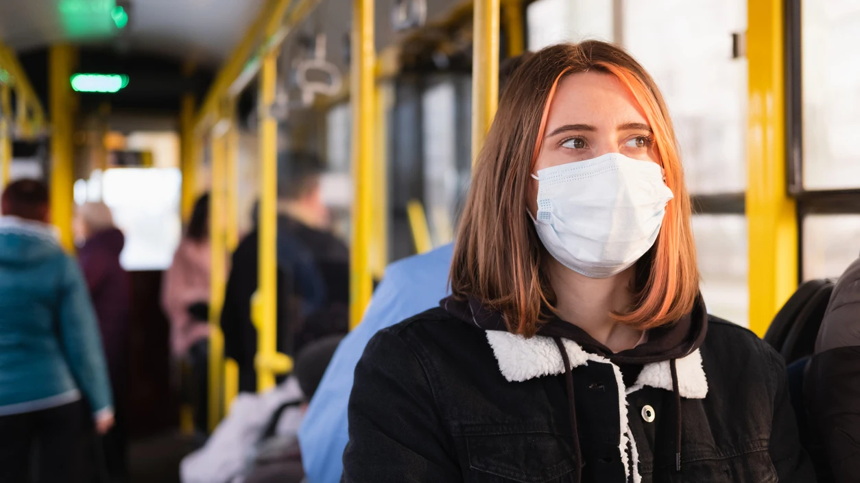 Una chica en un autobús con mascarilla