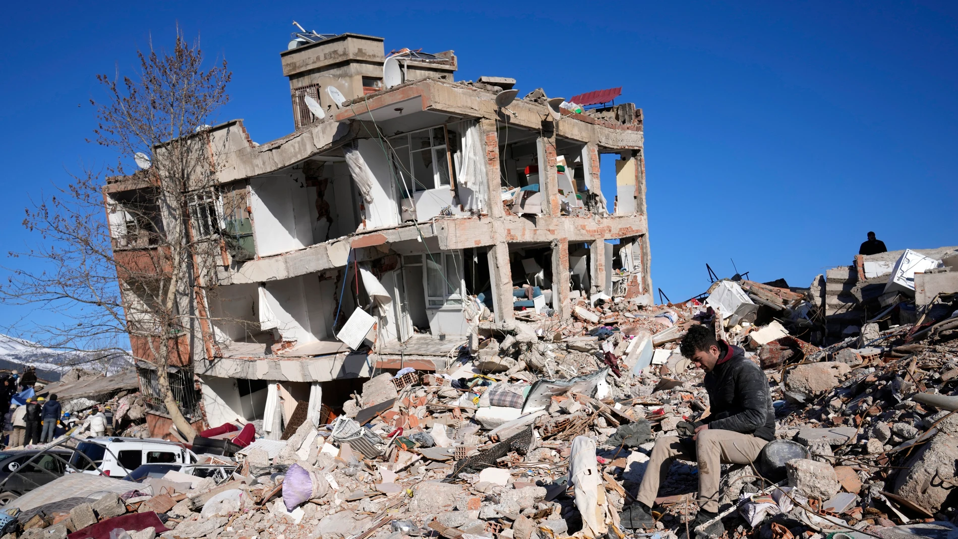 Un hombre sentado junto a una casa destruida en Kahramanmaras, tras el terremoto de Turquía