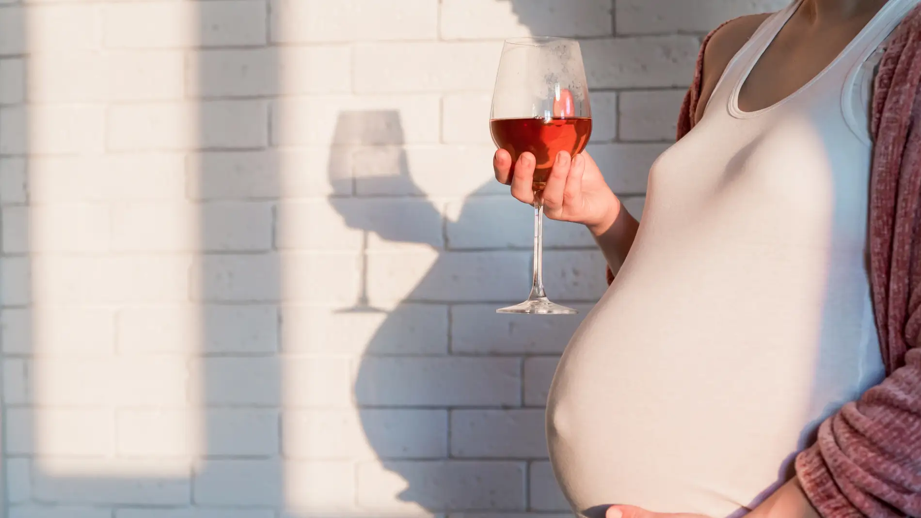 Embarazada con una copa de vino