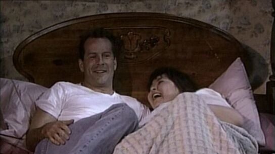 Bruce Willis con Roseanne Barr en la cama en una escena de créditos de la serie 'Roseanne'.