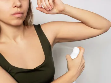 Mujer echándose desodorante Mujer echándose desodorante