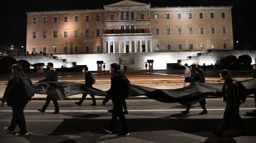 Estudiantes universitarios marchan por Atenas para protestar.