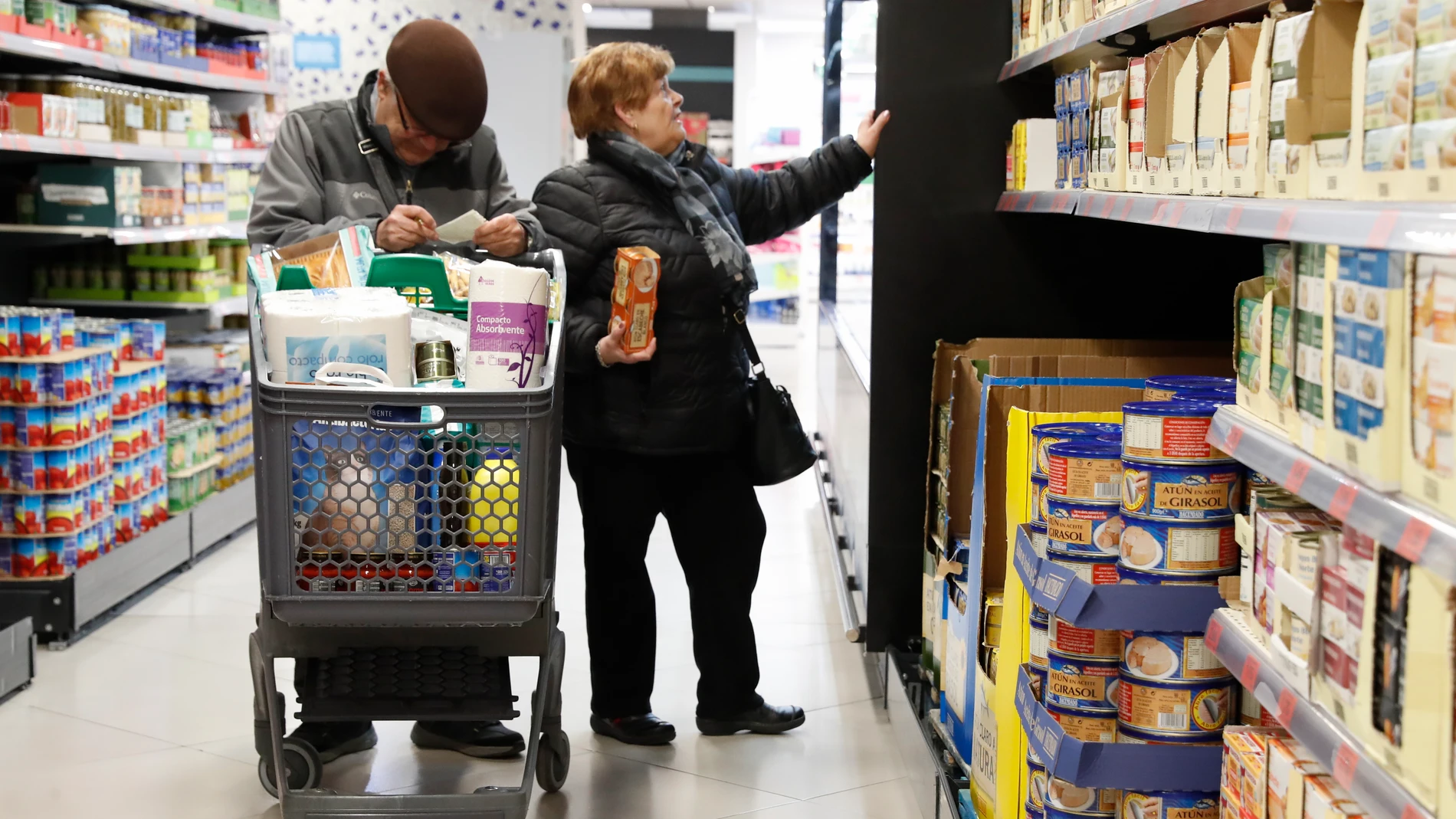 Dos personas hacen la compra en un supermercado.
