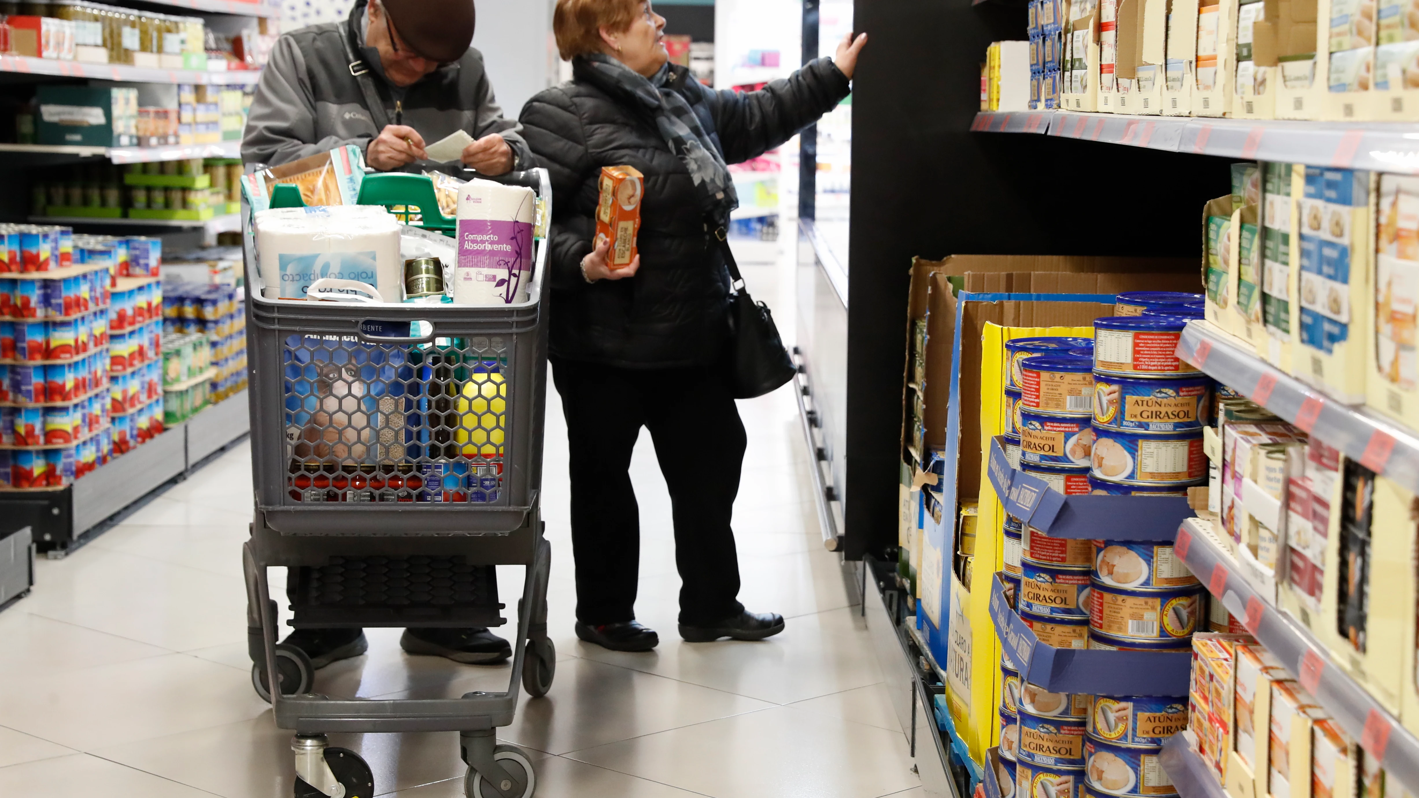 Dos personas hacen la compra en un supermercado.