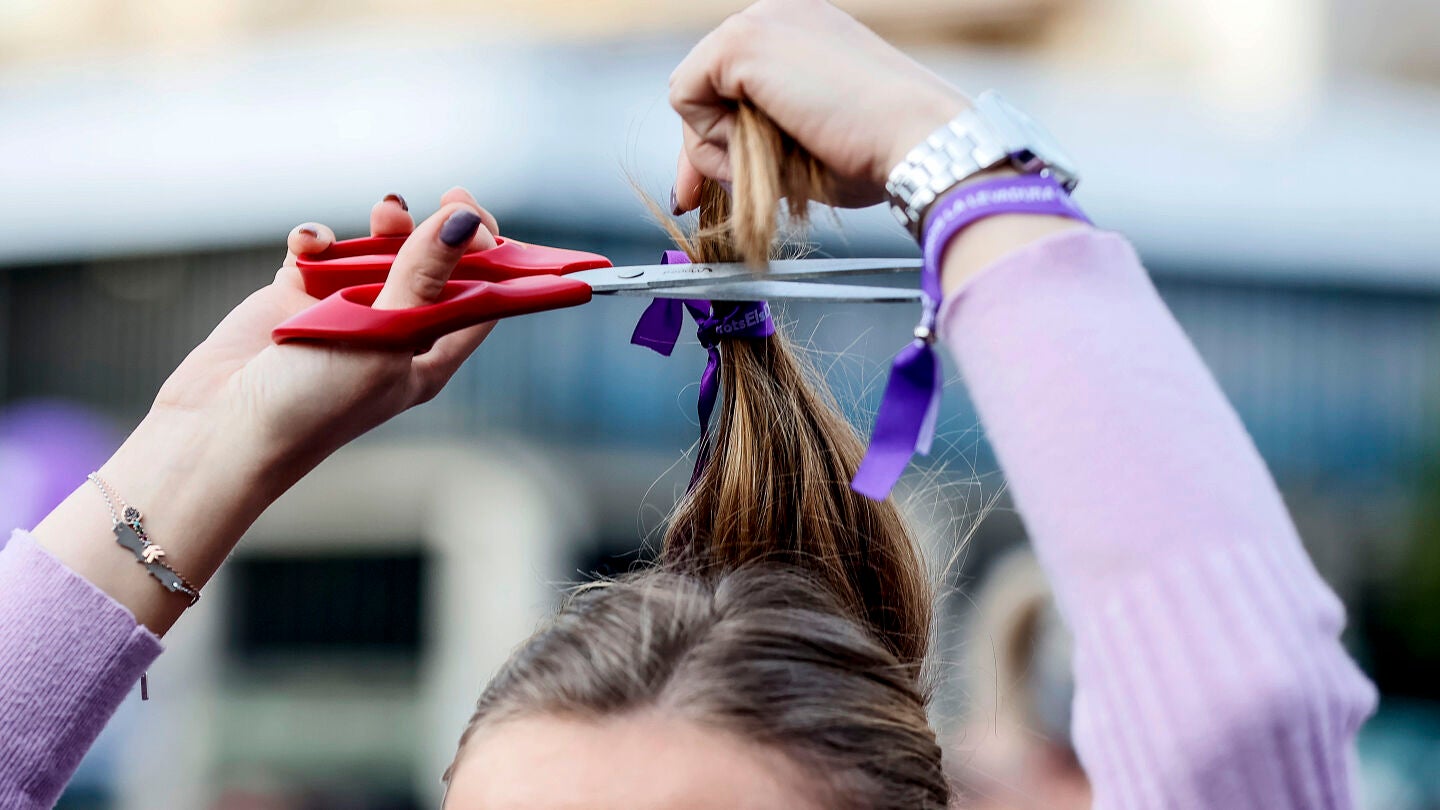 Una mujer realiza una acci&oacute;n colectiva de corte de pelo 'Tisorada al patriarcat' convocada por la Coordinadora Feminista de Val&egrave;ncia por el 8M
