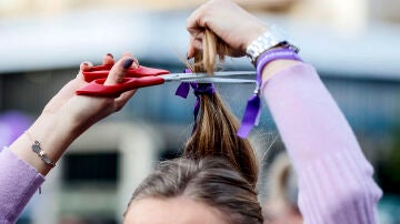 Una mujer realiza una acción colectiva de corte de pelo 'Tisorada al patriarcat' convocada por la Coordinadora Feminista de València por el 8M