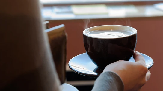 Imagen de una persona sujetando una taza de café Imagen de una persona sujetando una taza de café