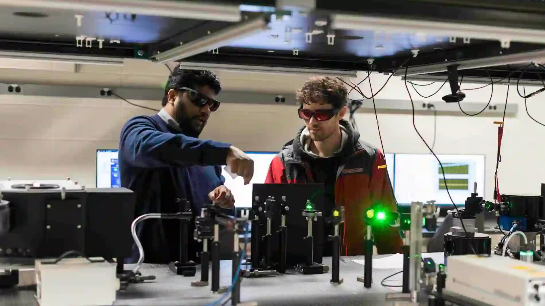 Los investigadores ajustan una matriz láser en su laboratorio de espectroscopia avanzada