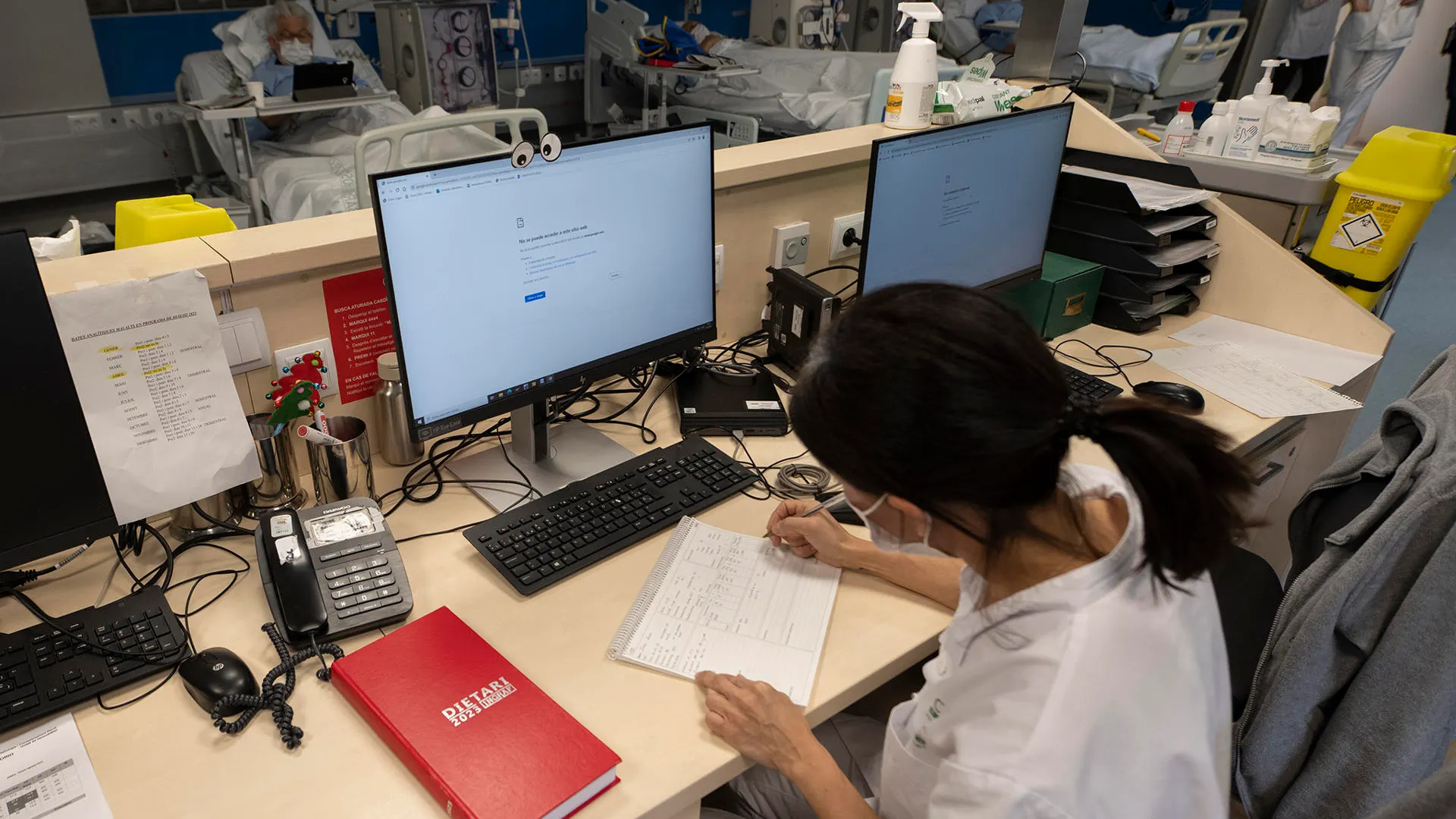 Una sanitaria del Hospital Clínic trabaja tomando notas a mano tras el ciberataque