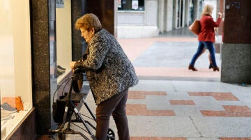 Una pensionista observa un escaparate en Barakaldo, Bizkaia