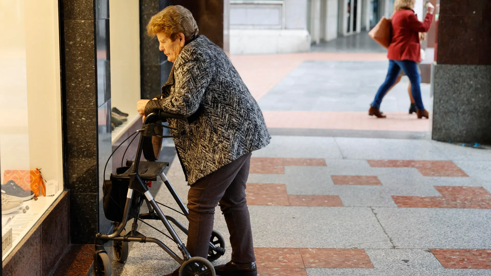 Una pensionista observa un escaparate en Barakaldo, Bizkaia