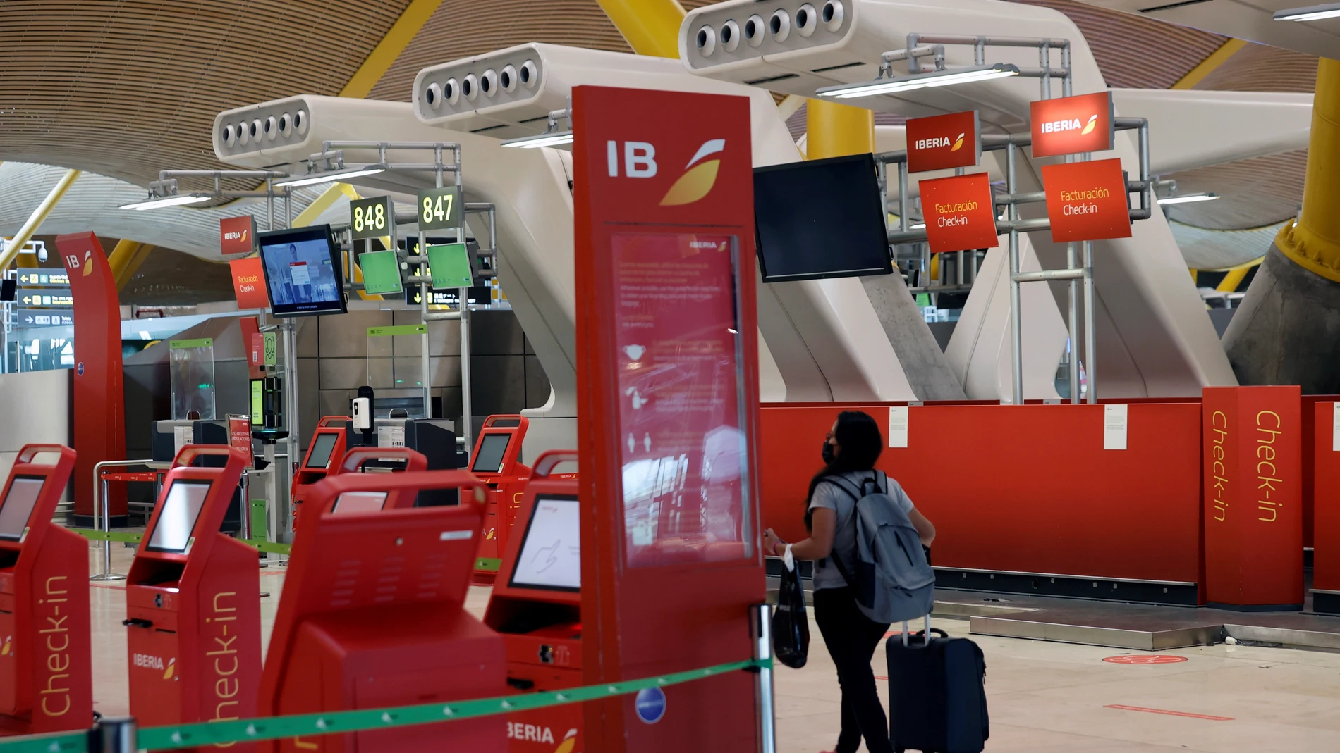 Una pasajera pasa ante los puestos de Iberia en el aeropuerto de Madrid-Barajas, en una imagen de archivo