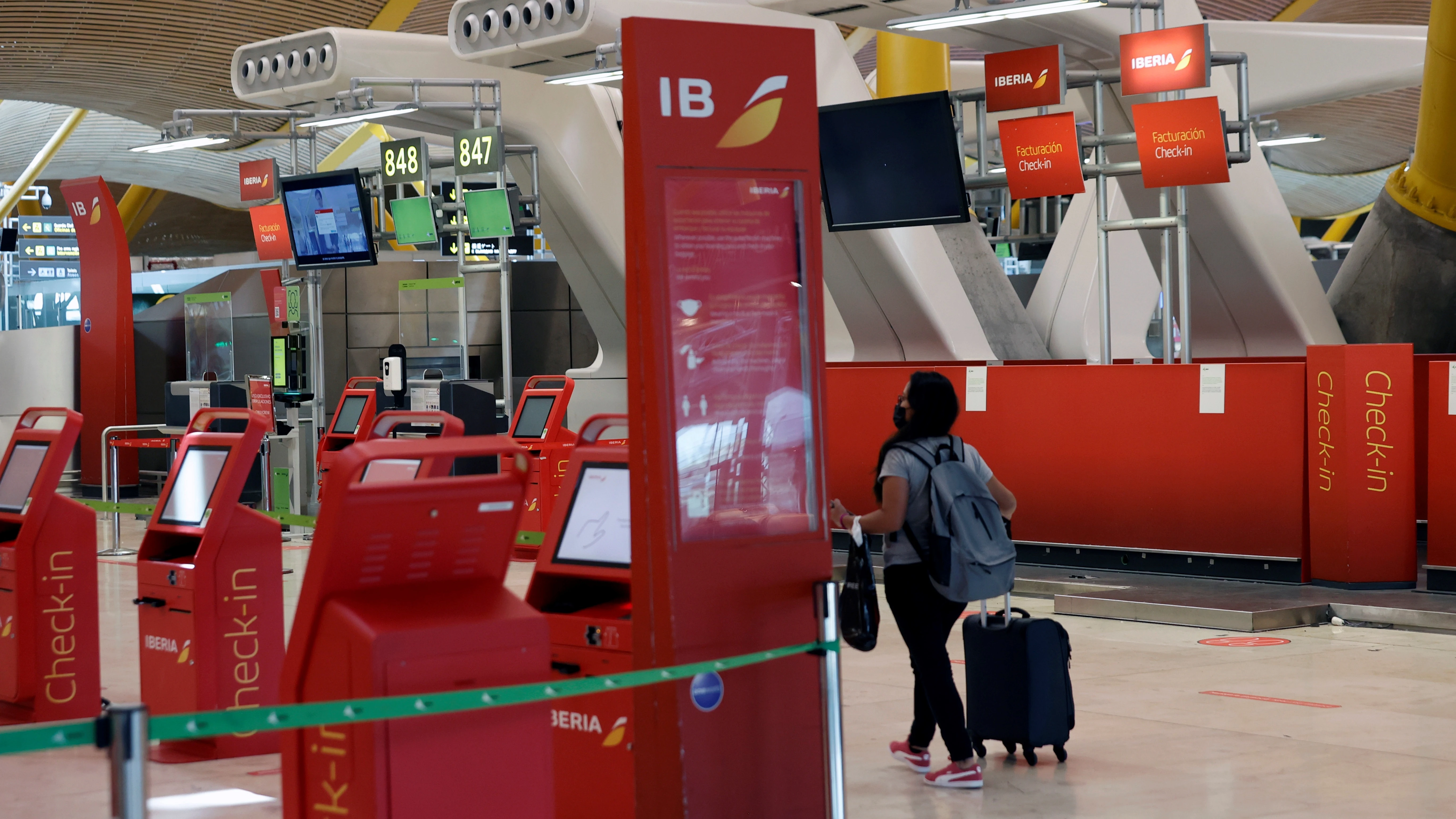 Una pasajera pasa ante los puestos de Iberia en el aeropuerto de Madrid-Barajas, en una imagen de archivo