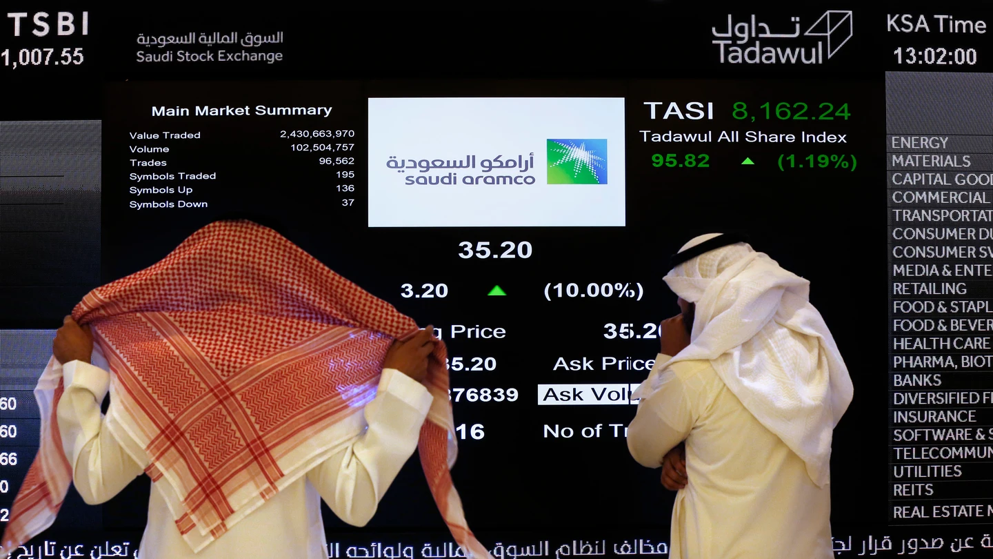 Dos personas observan la cotización en Bolsa de Aramco Dos personas observan la cotización en Bolsa de Aramco