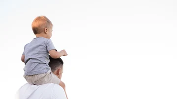 Un padre cargando a su hijo sobre los hombros