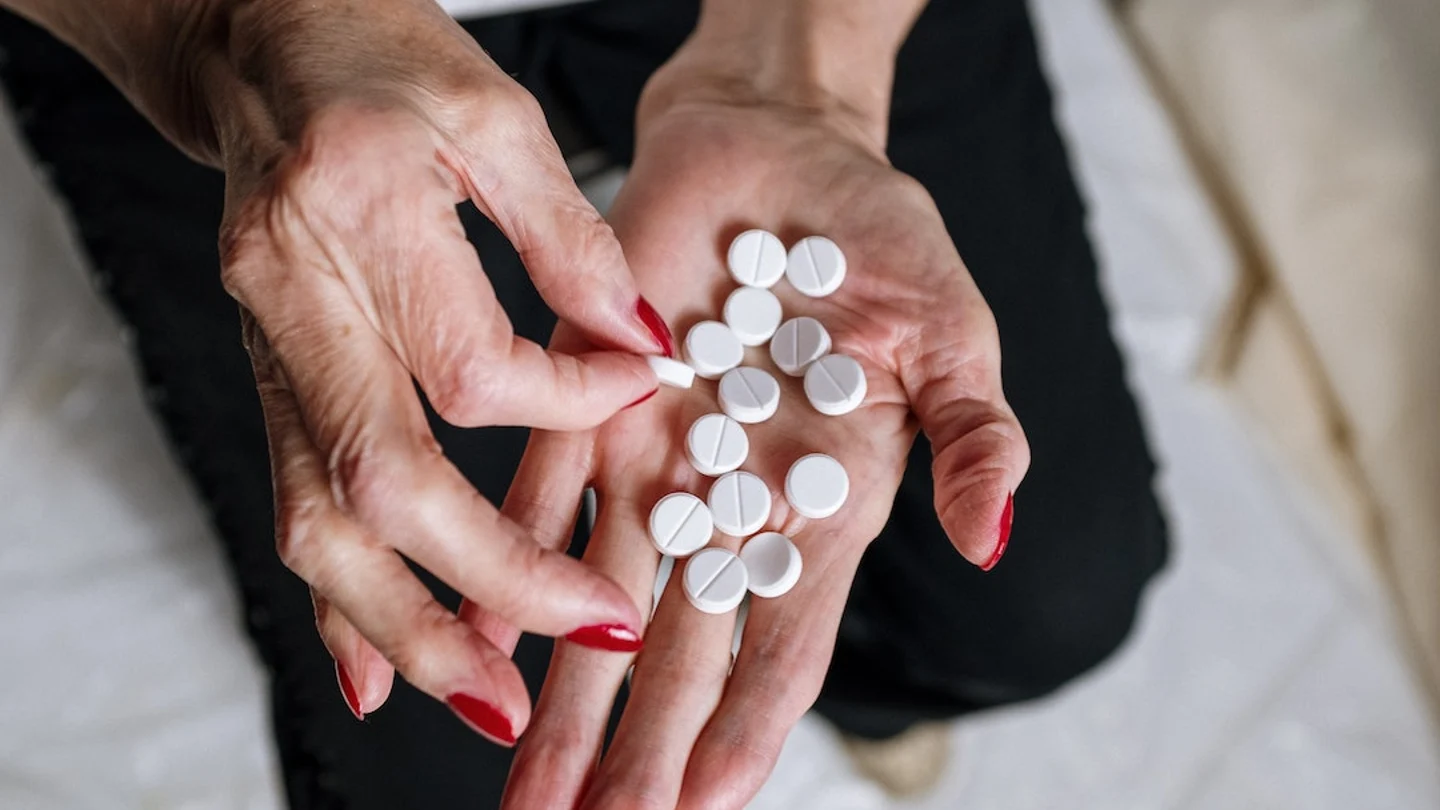 Imagen de archivo de una mujer mayor tomando pastillas Imagen de archivo de una mujer mayor tomando pastillas