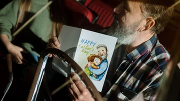 Un padre recibiendo una tarjeta de felicitación por el Día del Padre