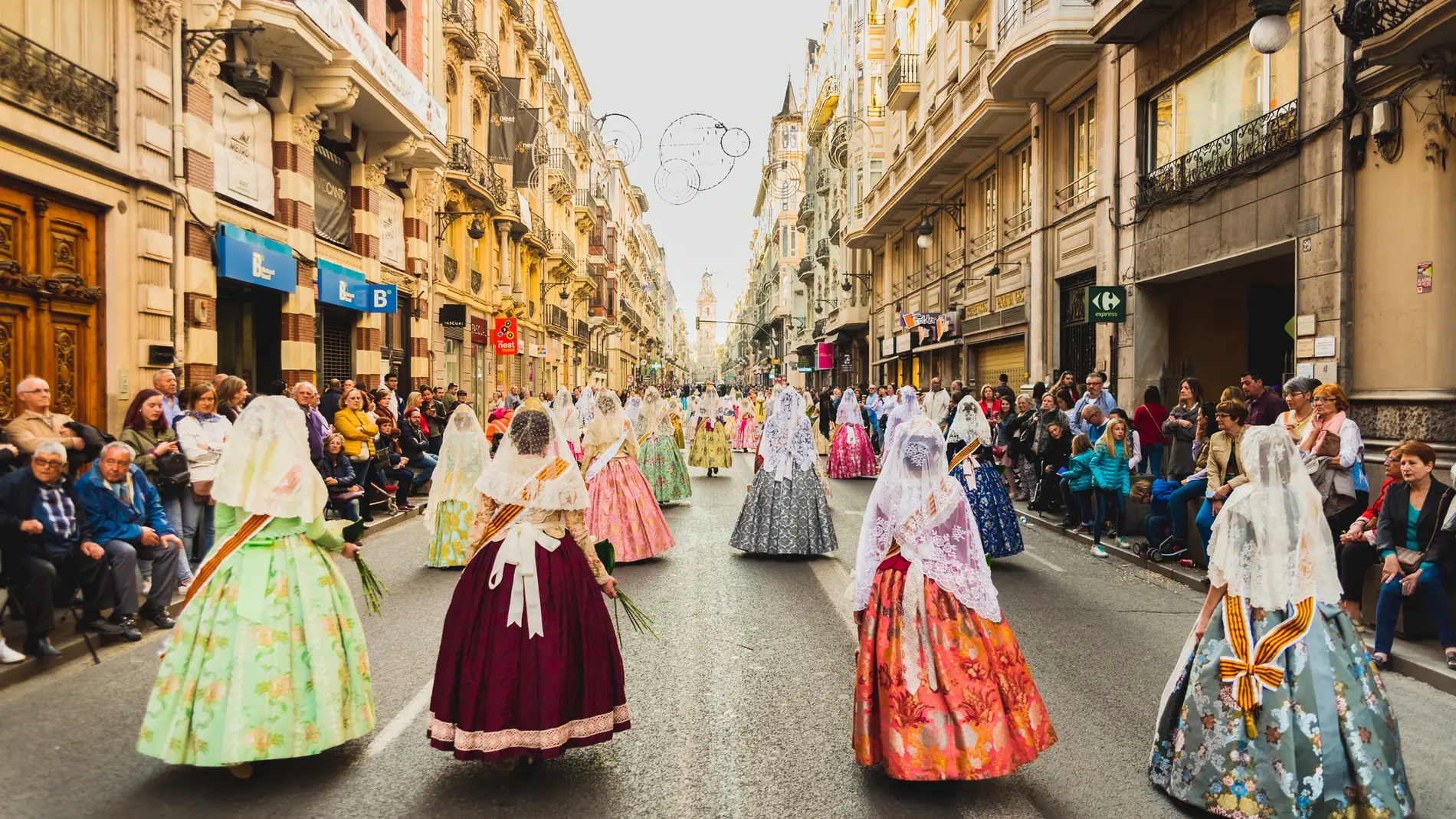 Falleras paseando por la calle de la Paz de Valencia durante las fallas