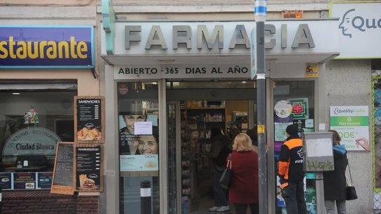 Imagen de archivo de varias personas esperando en la puerta de una farmacia Imagen de archivo de varias personas esperando en la puerta de una farmacia