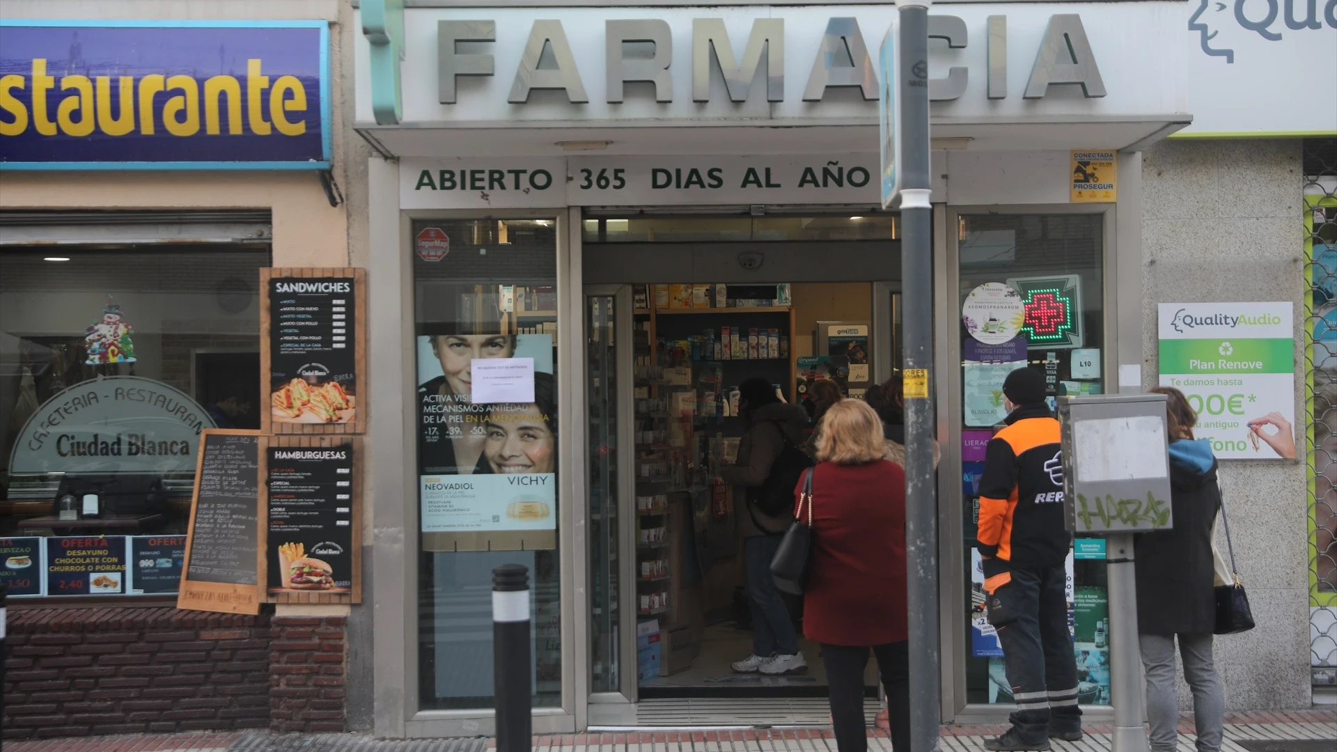 Imagen de archivo de varias personas esperando en la puerta de una farmacia 