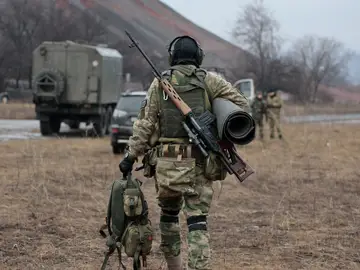 Un soldado del ejército ruso lleva su equipo después de la práctica en un campo de entrenamiento militar.