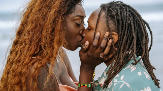 Fotografía de dos personas besándose en la playa Fotografía de dos personas besándose en la playa