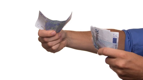 Las manos de un hombre sosteniendo varios billetes de 20 euros Las manos de un hombre sosteniendo varios billetes de 20 euros