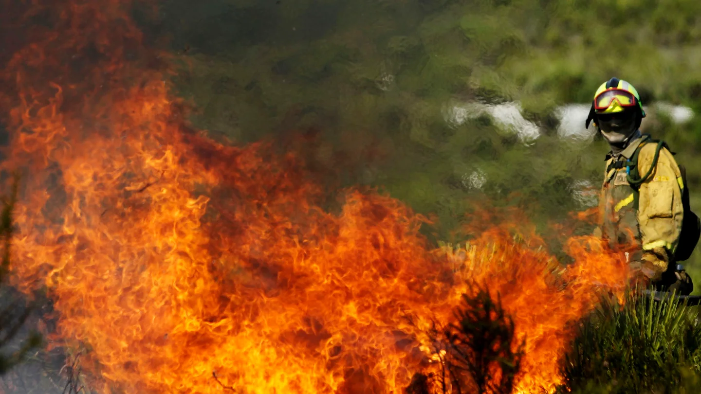 Imagen de archivo de un bombero luchando contra las llamas durante un incendio Imagen de archivo de un bombero luchando contra las llamas durante un incendio