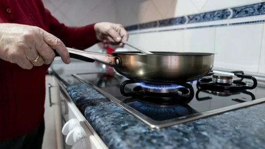 Una persona cocina sobre un fuego de cocina de gas Una persona cocina sobre un fuego de cocina de gas