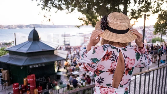 Una mujer con un vestido de flores y sombrero, de espaldas Una mujer con un vestido de flores y sombrero, de espaldas