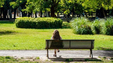 Una mujer toma el sol en un banco del Parque de Los Príncipes, en un día donde continúa el tiempo seco y soleado.