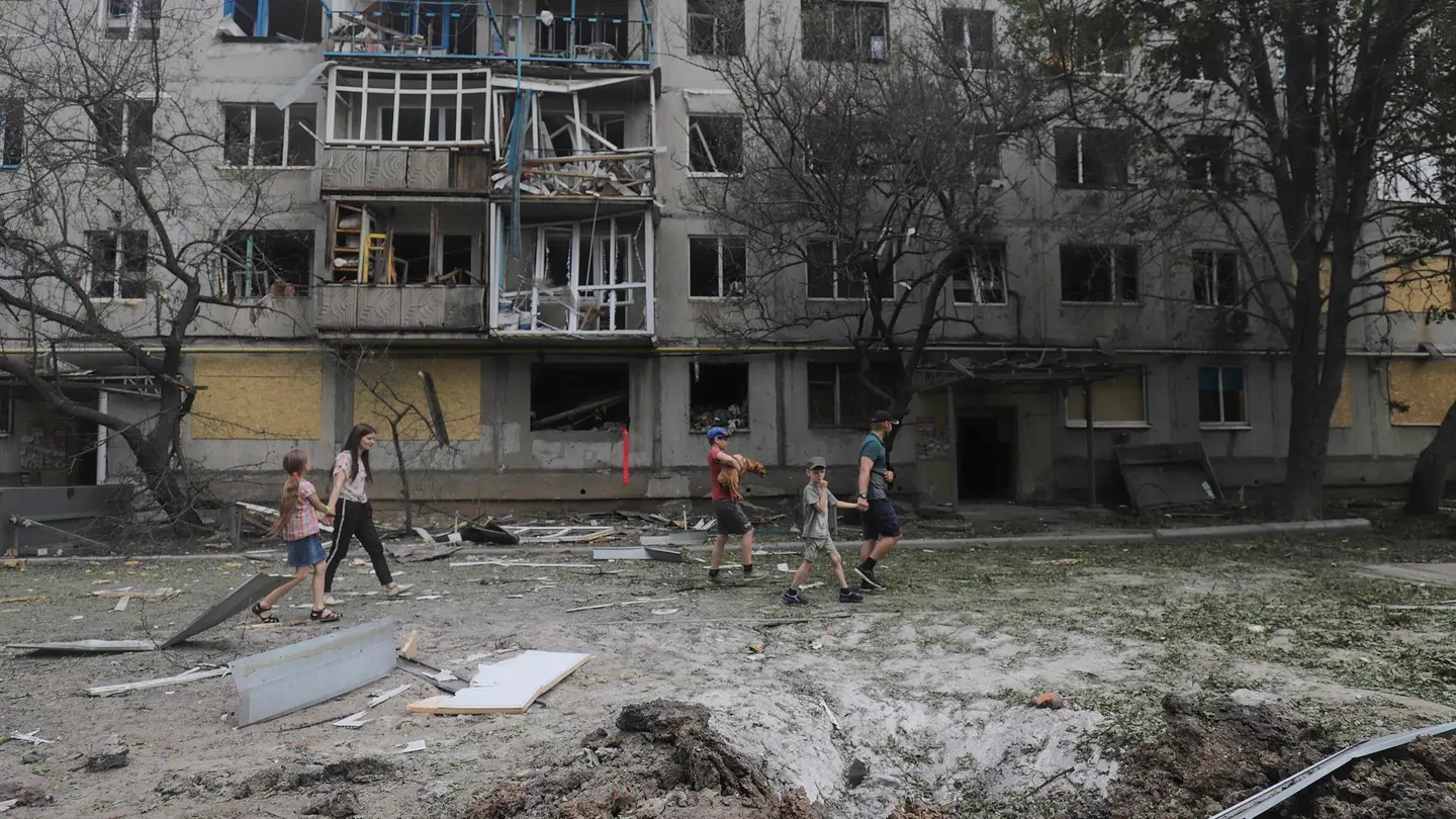 Imagen de ciudadanos frente a un edificio residencial dañado Imagen de ciudadanos frente a un edificio residencial dañado