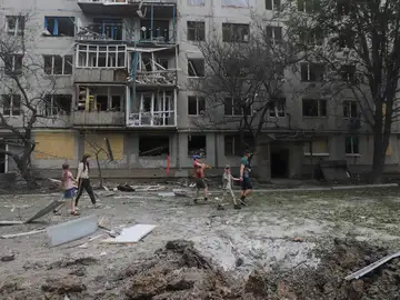 Ciudadanos pasan frente a un edificio residencial dañado en los recientes bombardeos en la ciudad de Bajmut, región de Donetsk, este de Ucrania.
