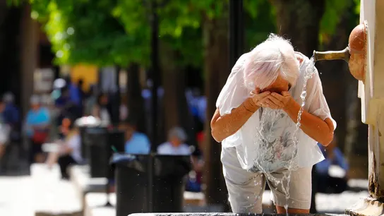 Una mujer se refresca en una fuente de Córdoba Una mujer se refresca en una fuente de Córdoba
