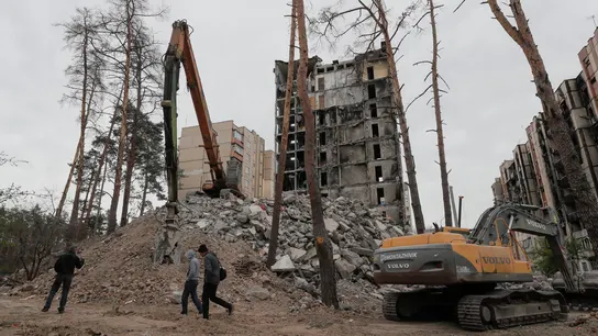 La gente camina frente a un edificio dañado durante las obras de demolición en Irpín, cerca de Kiyv, Ucrania, el 30 de abril de 2023. La gente camina frente a un edificio dañado durante las obras de demolición en Irpín, cerca de Kiyv, Ucrania, el 30 de abril de 2023.