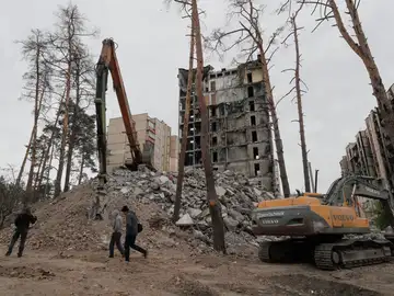  La gente camina frente a un edificio dañado durante las obras de demolición en Irpín, cerca de Kiyv, Ucrania, el 30 de abril de 2023.