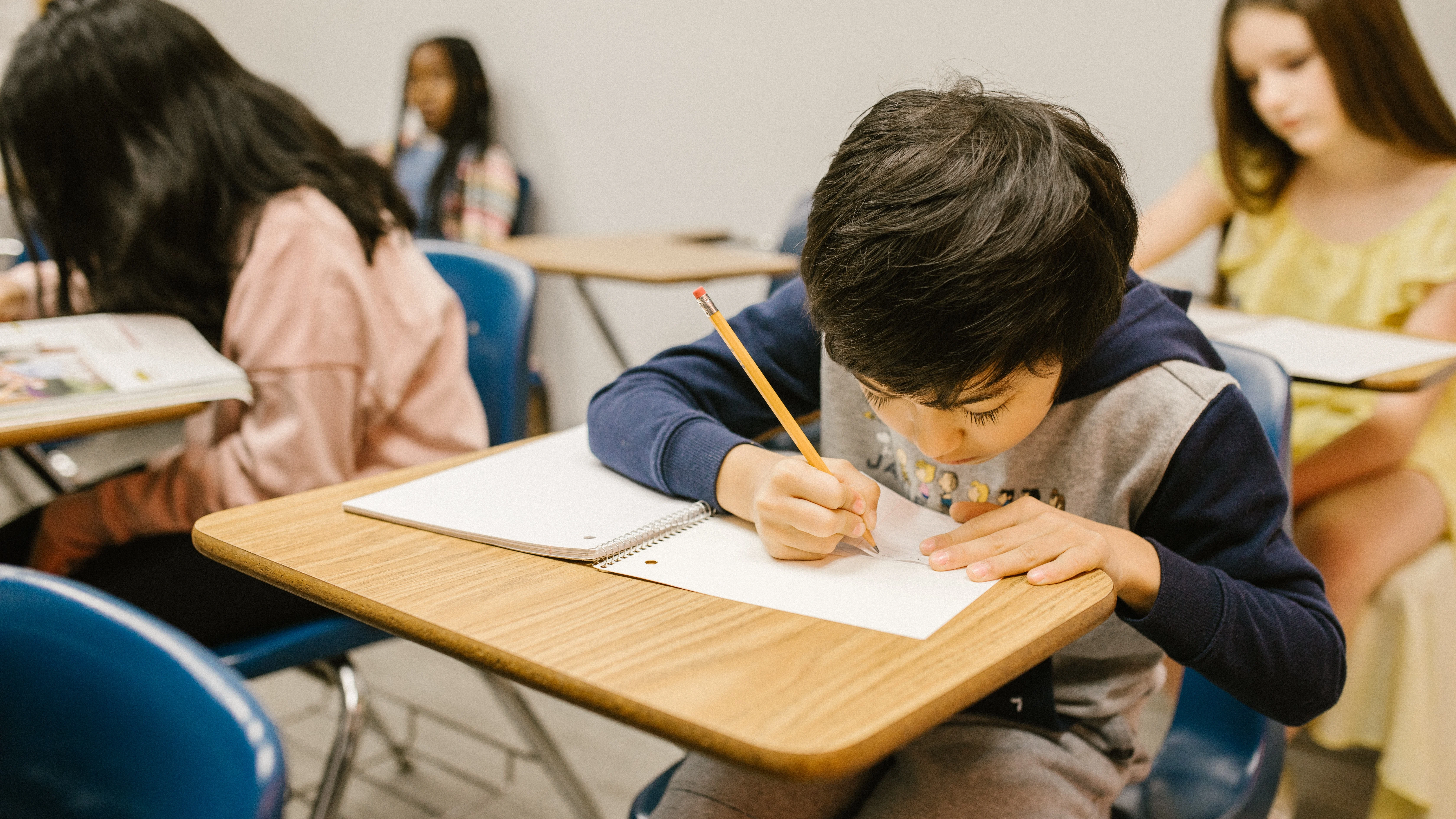 Un alumno escribe en un aula de un colegio