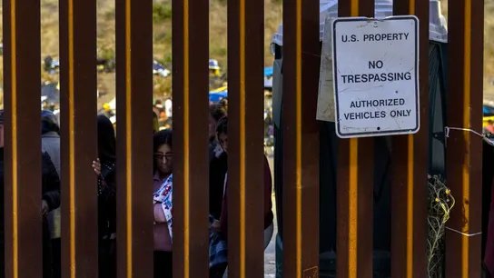 Migrantes miran a través del muro entre Estados Unidos y México, en San Diego, California, 12 de mayo de 2023. Migrantes miran a través del muro entre Estados Unidos y México, en San Diego, California, 12 de mayo de 2023.