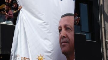 Varios ciudadanos cerca de un gran póster electoral del presidente turco Recep Tayyip Erdogan durante la campaña electoral.
