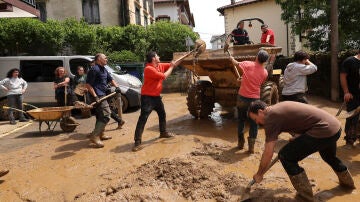 Los vecinos de Bera (Navarra) se afanan en limpiar sus locales, domicilios y calles tras el desbordamiento del río Zia, este sábado.