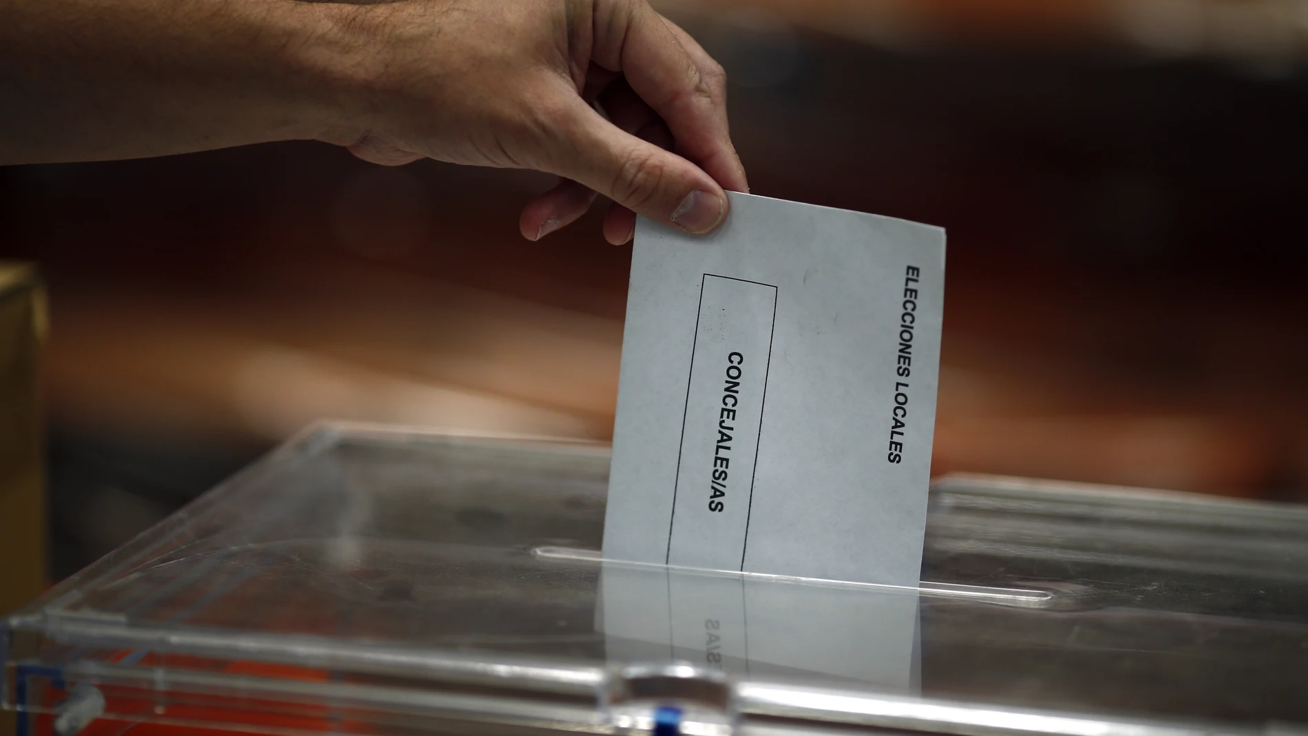 Una persona depositando el voto en una urna.