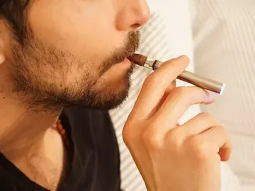 Hombre vapeando con un cigarrillo electrónico Hombre vapeando con un cigarrillo electrónico