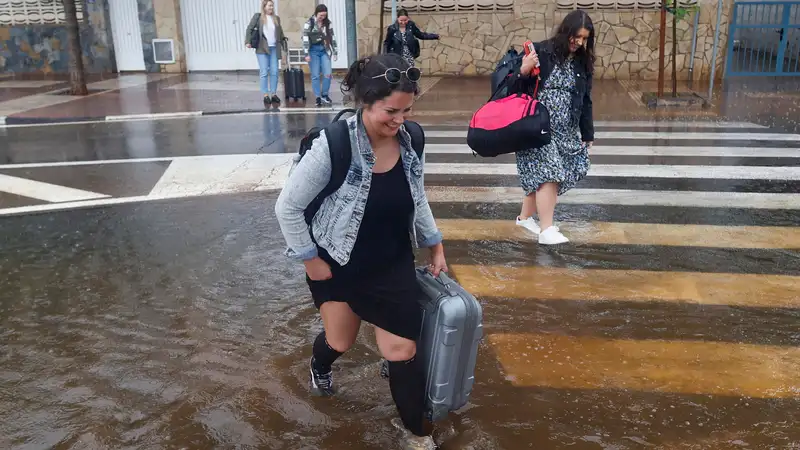 Varias personas cruzan una calle inundada tras el episodio de lluvias torrenciales en Castellón