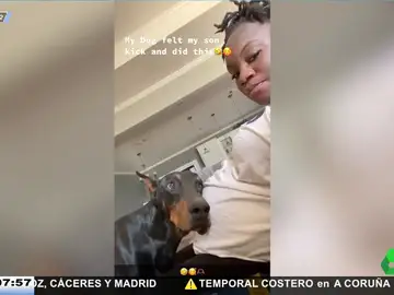 Un perro apoya la cabeza en la tripa de su dueña embarazada para escuchar las pataditas del bebé