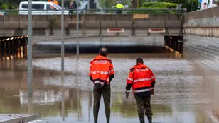 Dos bomberos contemplan un túnel inundado en la ciudad de Castelló